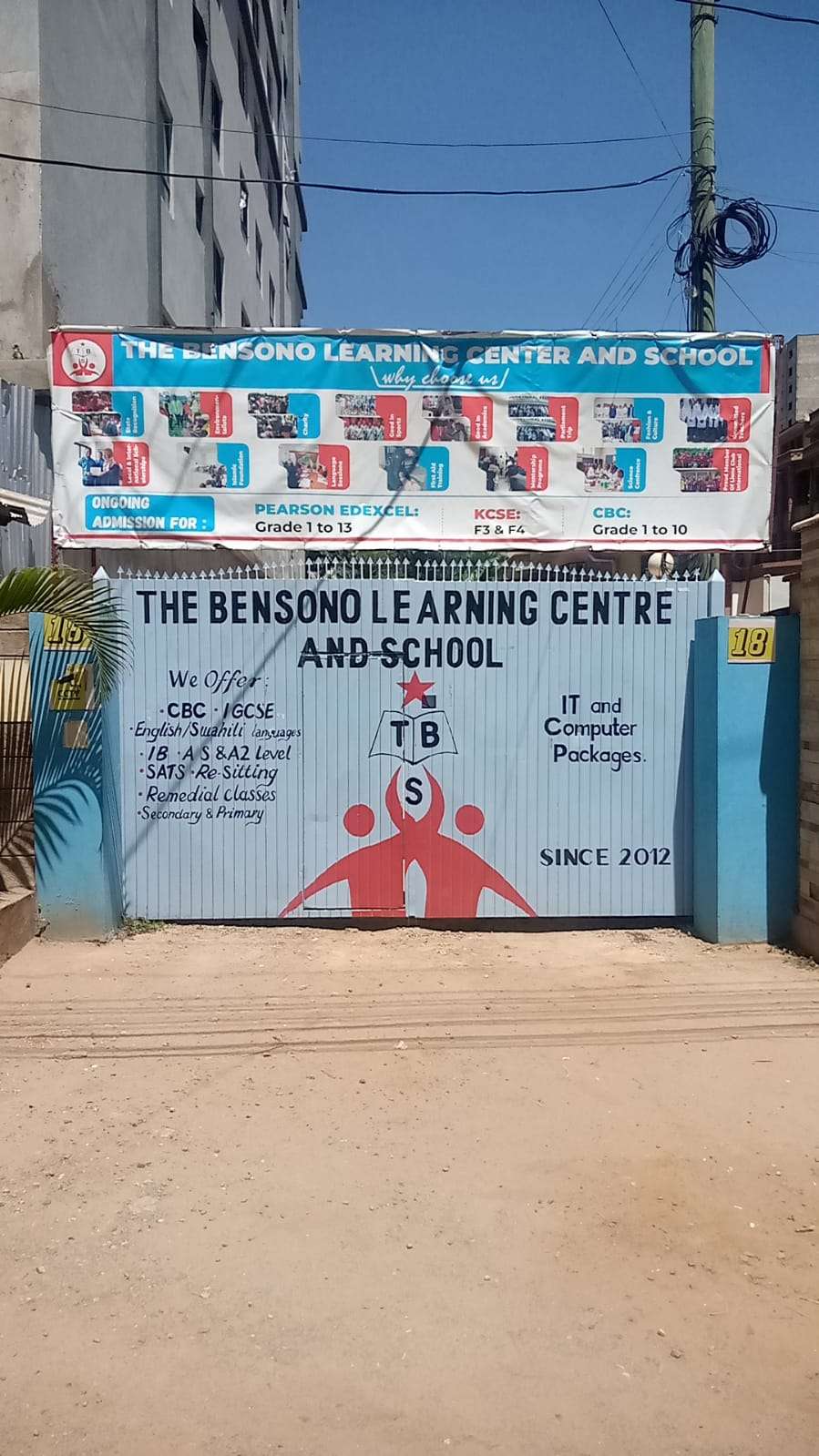 Entrance to the bensono learning centre and school branded gate with offical logo and banner